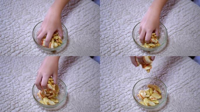 孩子的手从家庭厨房的盘子里拿薯条。有快餐