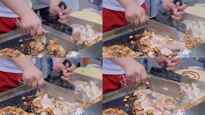 慢动作: 厨师在街头美食节上在烤架上切鸡肉