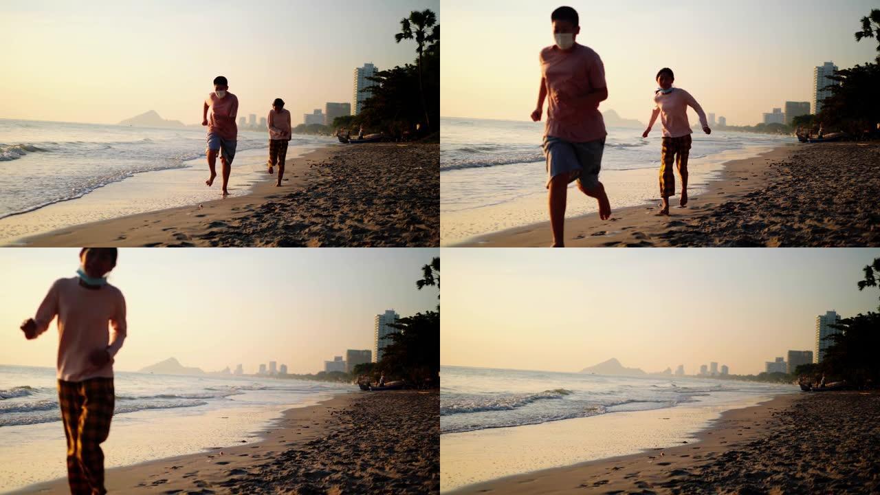 快乐的亚洲孩子早上一起在沙滩上奔跑，带着阳光，度假概念。
