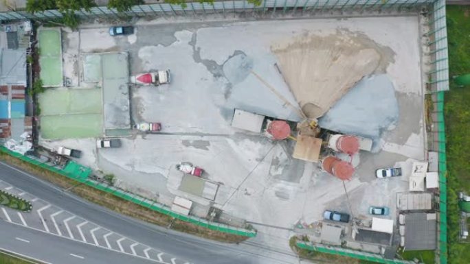 水泥厂工业现场的空中俯视图，带有卡车和沙子。