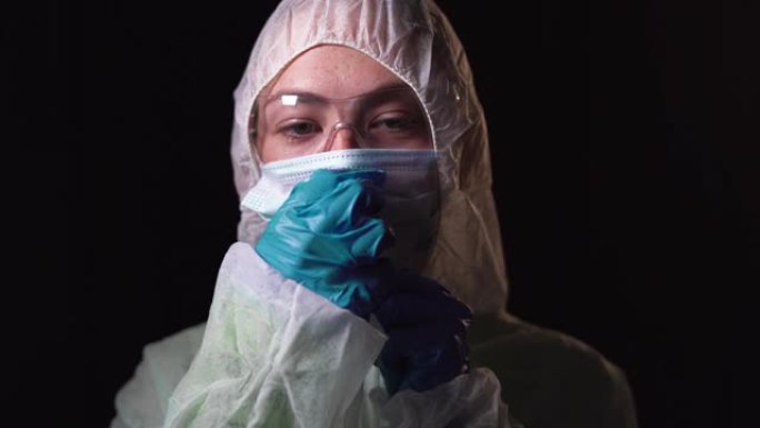 穿着白色防护服的年轻女医生的肖像照。在脸上戴上医用口罩。打击新型冠状病毒肺炎的概念