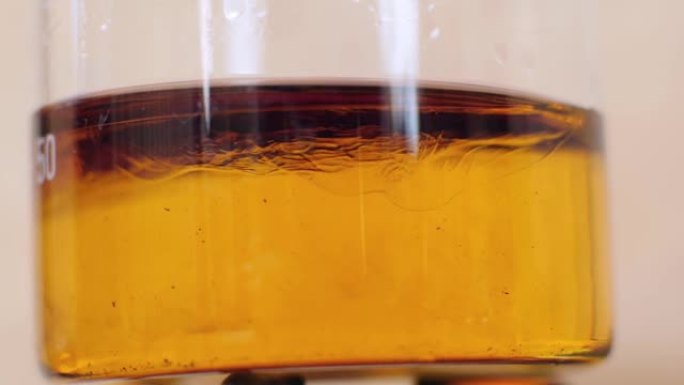 宏观。亚麻籽油在酒精燃烧器上的玻璃烧瓶中煮熟。加热亚麻籽油。木工中的亚麻籽油。