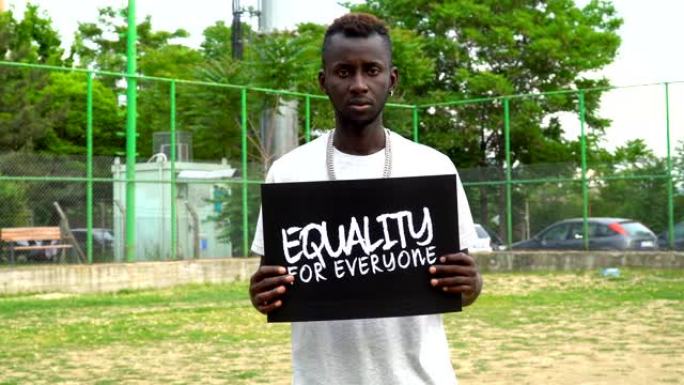 非洲青年抗议者手持纸板“人人平等”