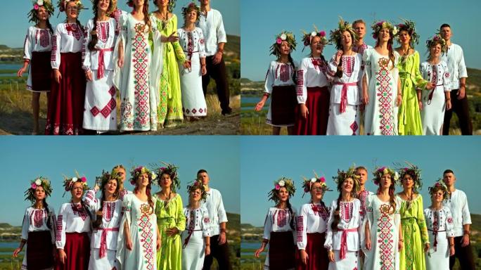 一群身着民歌服装的歌手，美丽的乡村景观。妇女穿着刺绣，头上有鲜花花环，斯拉夫民族的传统和习俗。4k，