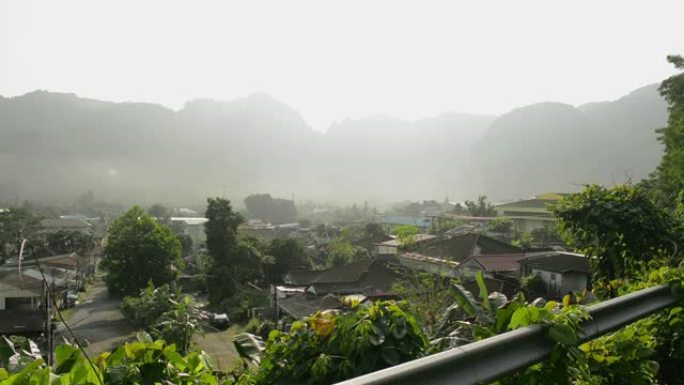 美丽的风景下的山谷小镇。村庄早晨的宁静。在日出的时候，从上面可以看到在自然和雾中居住的房子。
