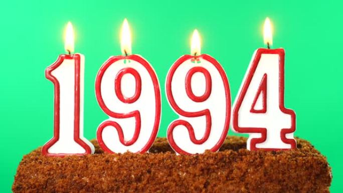 蛋糕与数字1994点燃的蜡烛。上个世纪的日期。色度键。绿屏。隔离