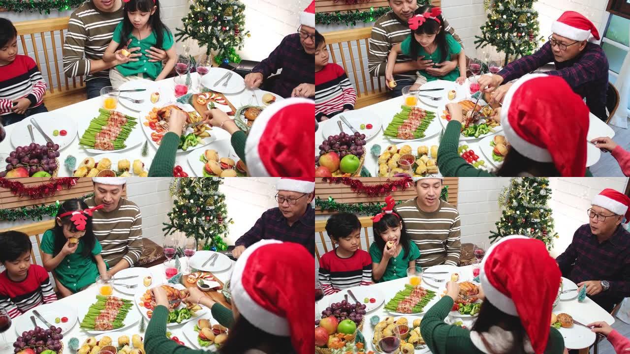 感恩节或圣诞节庆祝亚洲家庭晚餐概念。家庭有假日晚餐。快乐的家庭为聚会做饭。父亲母亲和女儿，在家吃饭。