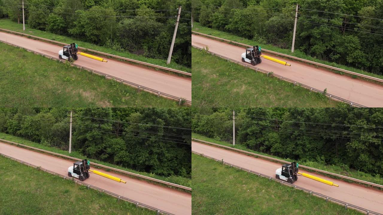 叉车装载机沿道路运送带套管的黄色管道