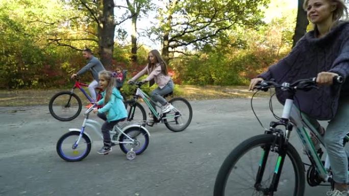 活跃的五口之家在公园骑自行车