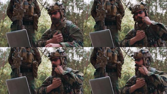 这是一幅身着军装、身穿战术背心、头戴头盔的指挥官肖像，他在笔记本电脑的键盘上打字，通过军用无线电报告