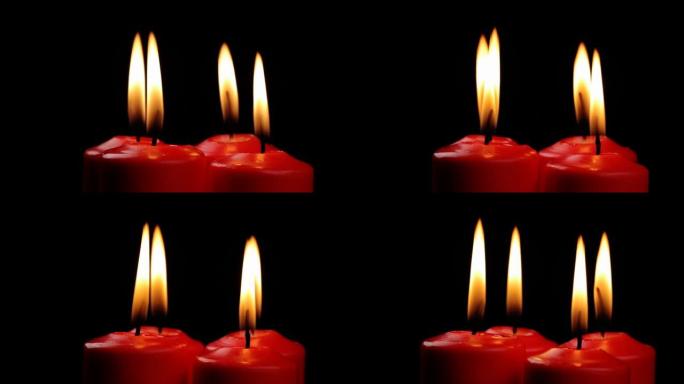 旋转四支红色蜡烛燃烧的火在黑色背景上缓慢旋转