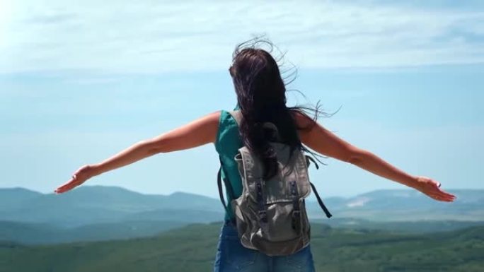 活跃的背包女在高山顶上举起双手，慢慢的。4k Dragon RED摄像机