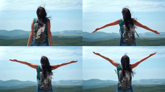 活跃的背包女在高山顶上举起双手，慢慢的。4k Dragon RED摄像机