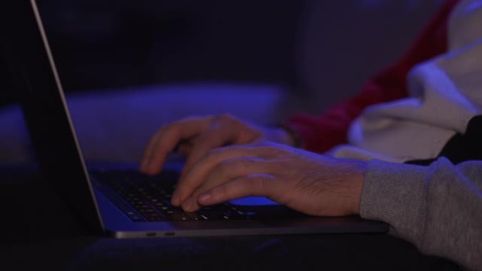 昏昏欲睡和疲倦的男人在半夜坐在家里的沙发上花时间使用智能手机。年轻的男学生晚上在电脑上工作到很晚。