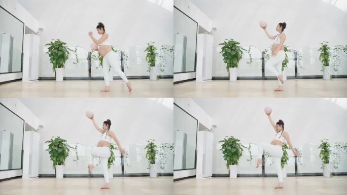 怀孕的现代女性在健身房锻炼身体练习瑜伽
