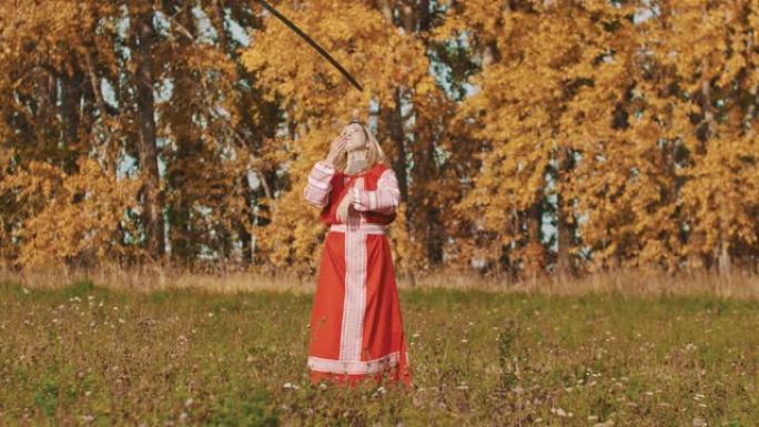 中世纪的概念-身着红色民族服饰的女人把剑绕着自己旋转