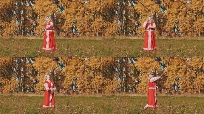 中世纪的概念-身着红色民族服饰的女人把剑绕着自己旋转