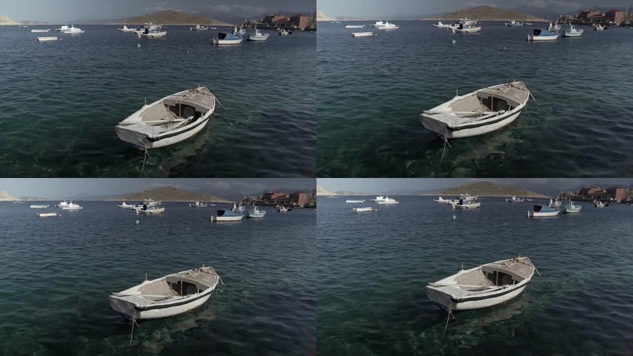 希腊Symi-2020年9月24日: 一艘白色的空船漂浮在地中海沿岸的Symi岛沿岸的清澈海水上，靠