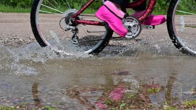 自行车车轮穿越水坑的慢动作视频
