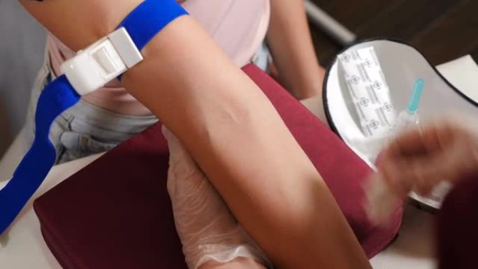 诊所的实验室。女性实验室助理在抽取静脉血进行测试前在女性患者手臂上应用止血带。HIV肝炎检测。医疗保