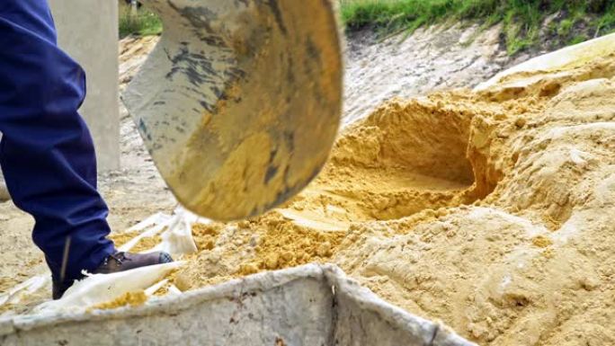 拉丁裔建筑工人在铲子的帮助下收集沙子