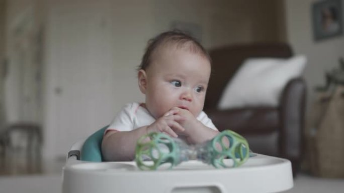 女婴坐在婴儿座椅上玩玩具