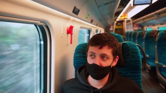 一名戴着口罩的男子在公共交通火车上移动