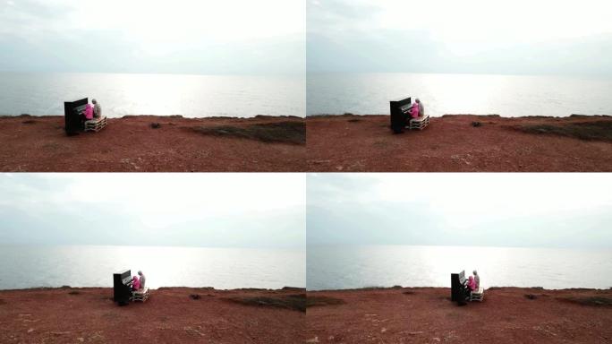 无人机的观点-在岩石海岸上，儿童女孩和老人一起在旧钢琴上演奏