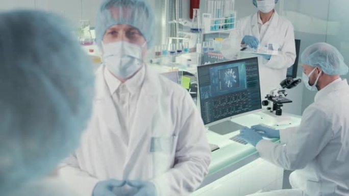 新型冠状病毒肺炎多样化的实验室团队致力于冠状病毒样品。穿着防护工作服