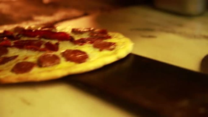 准备意大利香肠比萨饼-将比萨饼放入燃木烤箱中。意大利食物，膳食，午餐，美食，餐厅，转