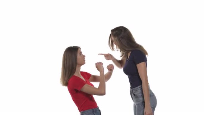 争吵中高加索双胞胎姐妹的侧视图。穿着黑色t恤的女人责骂她的妹妹，这表达了恐惧并慢慢倒下。家庭中的虐待