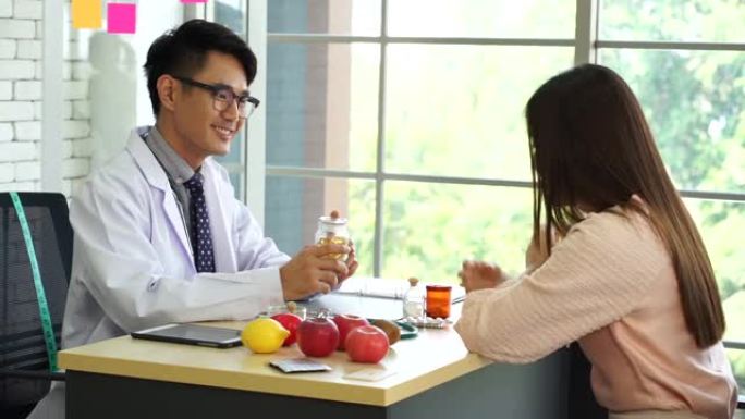 年轻的男性医生戴眼镜和听诊器给病人建议素食营养健康饮食免疫预防新型冠状病毒肺炎病毒大流行