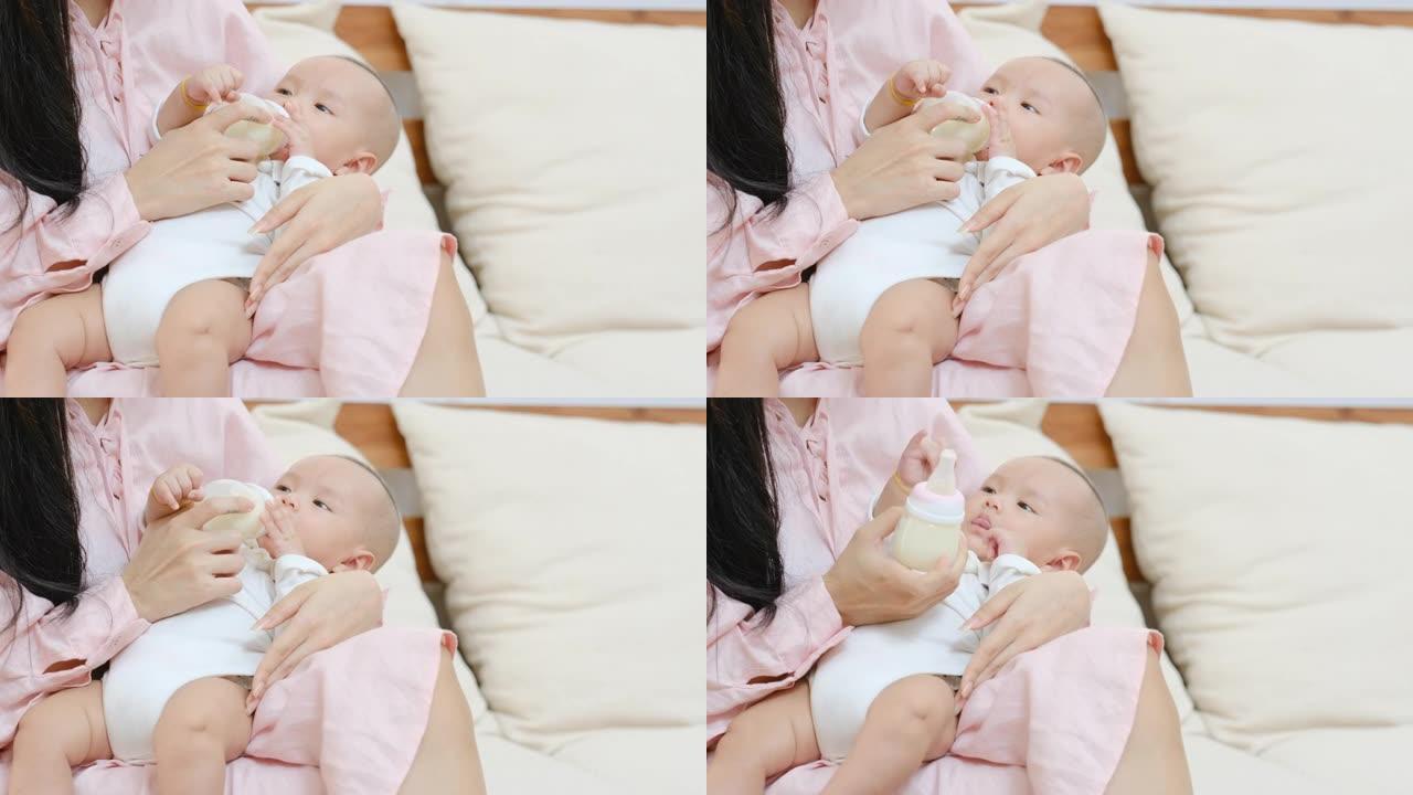 关闭刚出生的婴儿喝奶瓶中的牛奶，躺在卧室里他年轻母亲的腿上。母亲看着她的孩子