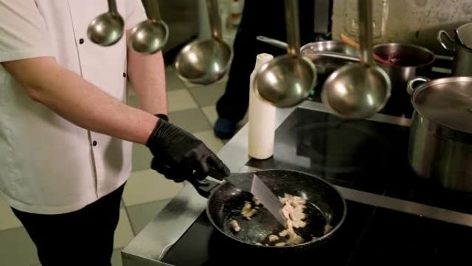 厨师在餐厅厨房的煎锅中煎炸鸡肉的特写镜头