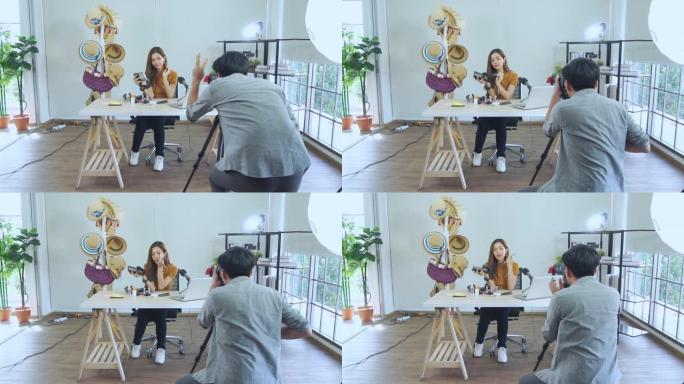 年轻的亚洲夫妇博主录制vlog视频，有影响力的人在工作室用化妆化妆品在社交媒体上直播，在家学习的在线