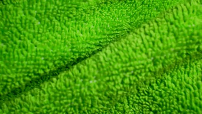 摘要背景柔软的绿色织物特写。皱巴巴的布