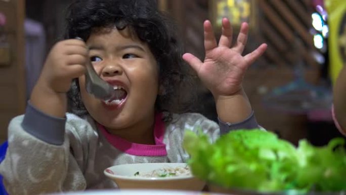 快乐的女孩用勺子吃美味的食物