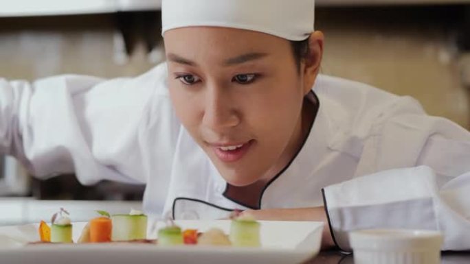 美丽的亚洲女厨师在面对镜头微笑的同时为牛排增添了点睛之笔。