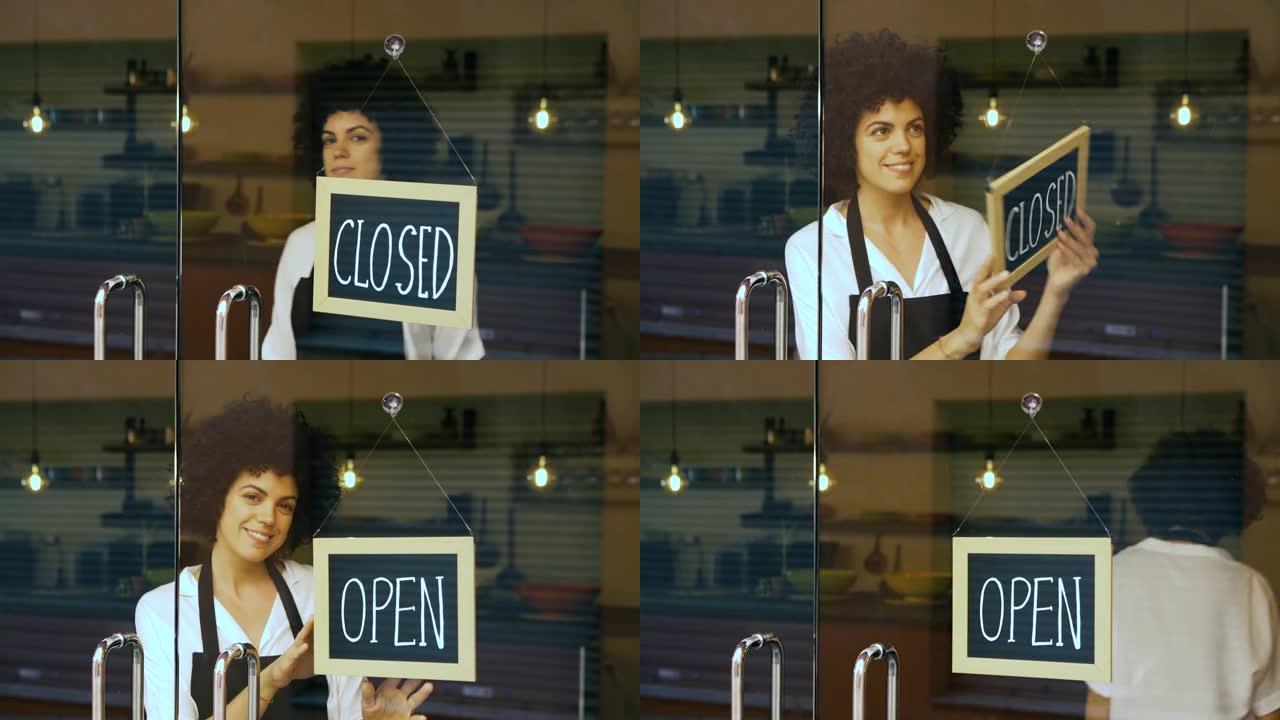 微笑的女商人在玻璃门上贴上打开的标志。