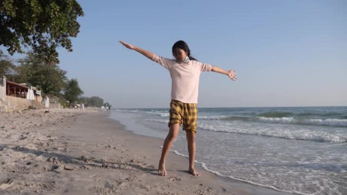 快乐的亚洲女孩早上在海滩上做翻筋斗，与家人一起度假，生活方式理念。