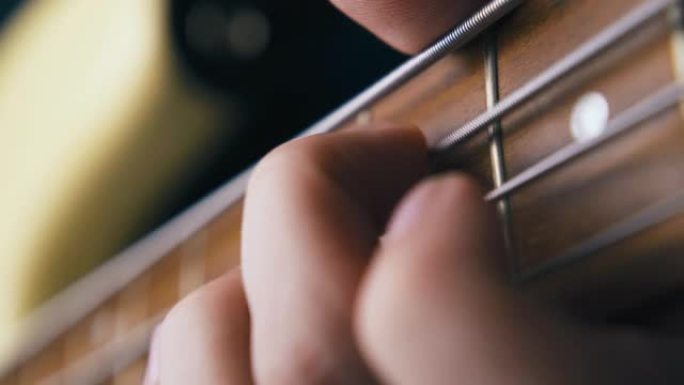 艺术家手指用音高转换技术演奏低音吉他