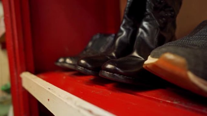 鞋匠车间的架子上有一双靴子和运动鞋