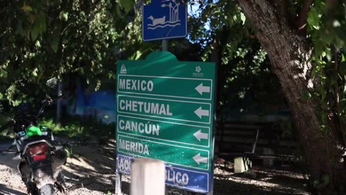 墨西哥方向标志包围着三人和摩托车
