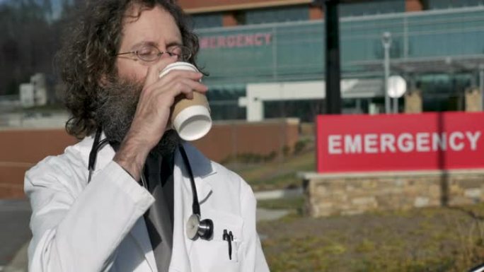 疲惫，疲惫的男医生在急诊医院外喝咖啡