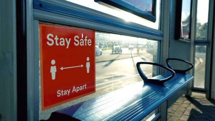 在到达巴士的巴士站保持安全的大流行标志