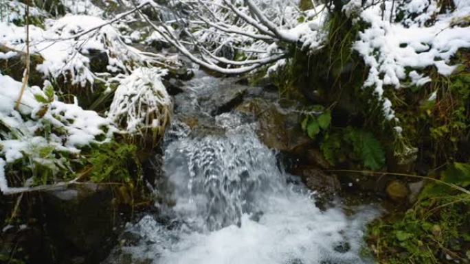 慢动作。在山河上下雪，流淌着石头巨石和石头急流。小溪里快速泼水。冬天的山溪。