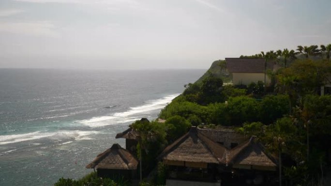 阳光灿烂的巴厘岛著名的melasti海滩豪华山顶酒店平房慢动作全景4k印度尼西亚