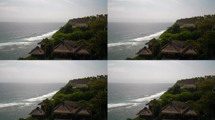 阳光灿烂的巴厘岛著名的melasti海滩豪华山顶酒店平房慢动作全景4k印度尼西亚