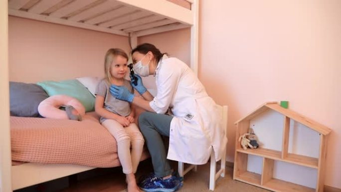锁定期间，儿科医生用耳镜检查小女孩的耳朵，在家中进行耳鼻喉科检查