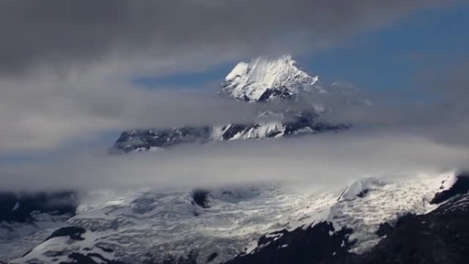 从费尔威斯特山山脉缩小到低云之间，与阿拉斯加冰川湾国家公园的约翰·霍普金斯冰川景观。